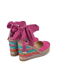 Décolleté in suede fucsia con tacco a zeppa e dettagli intrecciati in corda colorata, accompagnate da ampi lacci alla caviglia. Design con zeppa per un'altezza e una stabilità extra.