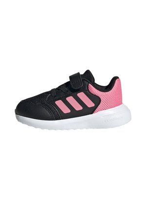 Scarpe sportive nere con accenti in rete rosa, tre strisce rosa, una fascia in velcro e una suola in gomma bianca con un motivo testurizzato.