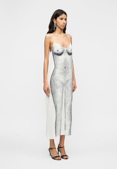 Μάξι φόρεμα με λεπτές τιράντες, με γραφική ασπρόμαυρη απεικόνιση σώματος, μαλακό ύφασμα και εφαρμοστή σιλουέτα. Μαύρα πέδιλα με λουριά.