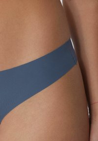 Braguita de bikini azul de talle alto con una tela suave y elástica; detalle de costura minimalista a lo largo de la cinturilla y lados sin costuras.