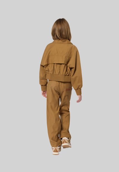 Bruine bomberjack met ribbed manchetten en zoom, gecombineerd met bijpassende broek. Beide kledingstukken hebben een gladde textuur en een relaxte pasvorm.