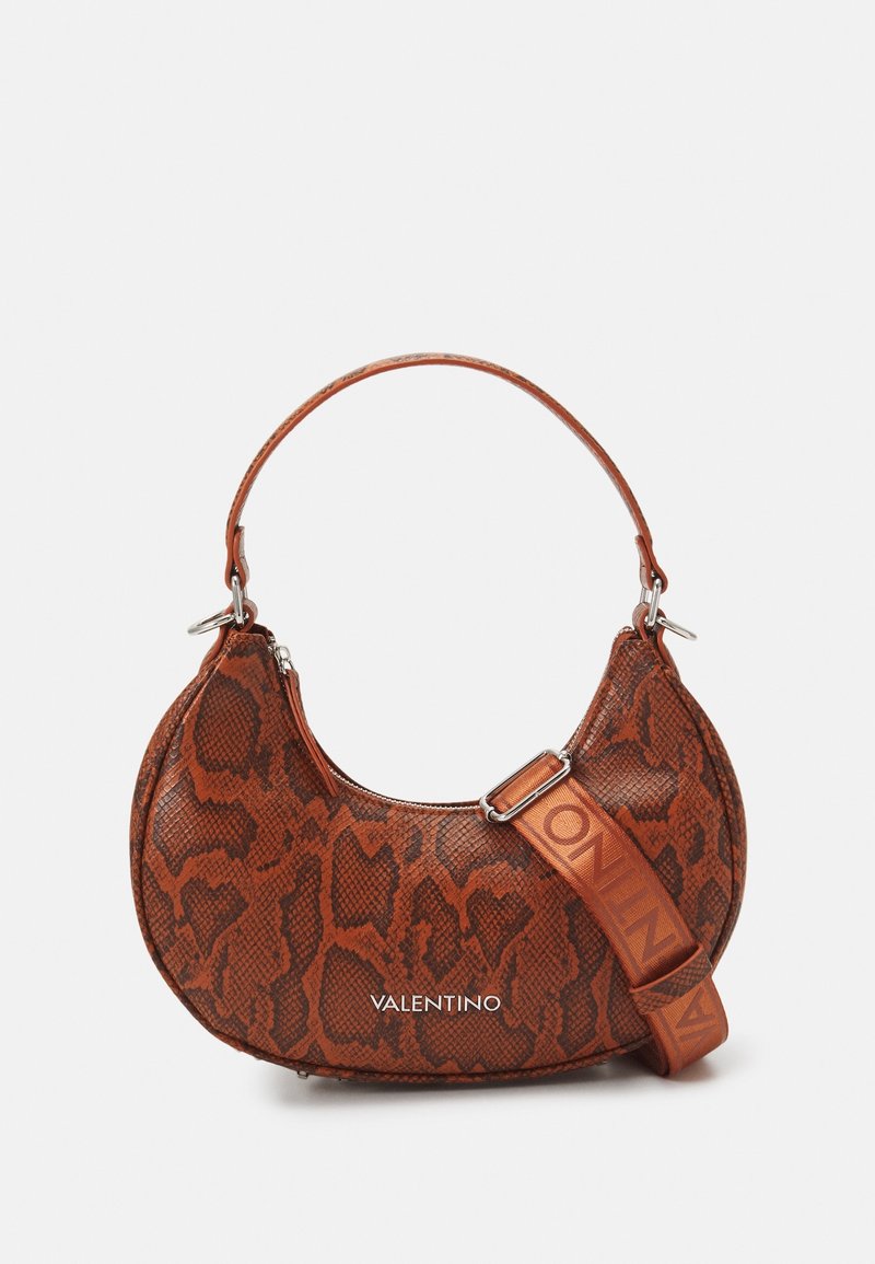 Ruskean käärmekuosisen käsilaukun kaareva muoto, jossa on lyhyt kahva ja säädettävä olkahihna. Logo näkyy edessä.