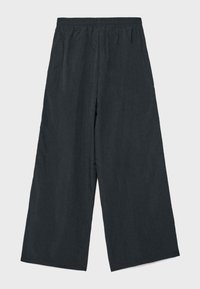 Sorte bukser med vide ben, elastisk talje, løs pasform og uden synlige lommer, vist mod en lys baggrund.