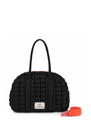 Schwarze gesteppte Handtasche mit zwei Griffen und einem weißen Etikett, begleitet von einem abnehmbaren leuchtend orangefarbenen Schulterriemen auf weißem Hintergrund.