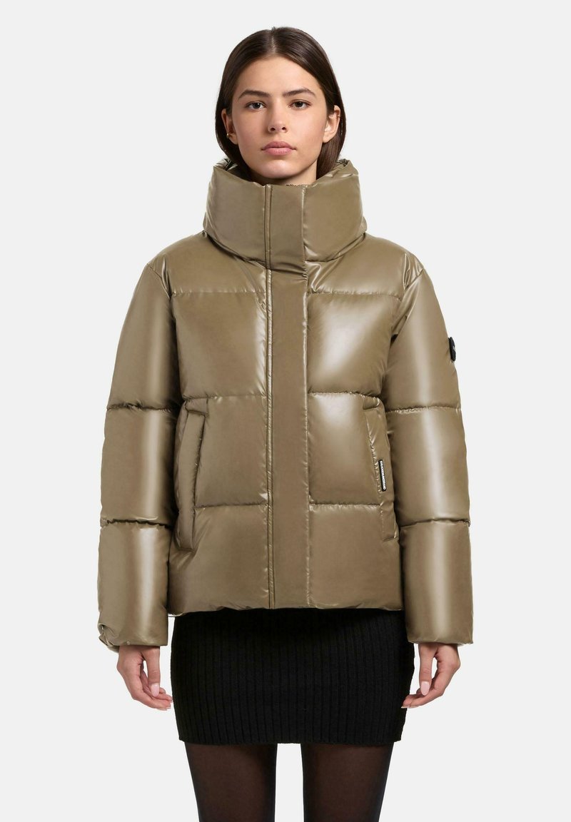 Olive green puffer jacket with high collar, shiny finish, quilted design, and front pockets; paired with a black ribbed mini skirt.
