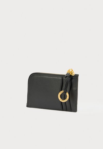 Crna kožna novčanica sa zatvaračem na patentni zatvarač, s naglaskom na zlatni prsten i teksturiranim bočnim panelima. Kompaktan i pravokutnog oblika.