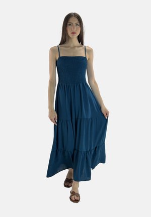 Teal, gelaagde maxi-jurk met een smock-bodice, spaghetti banden en zachte stof. Heeft een vloeiende ontwerp en een relaxte pasvorm.