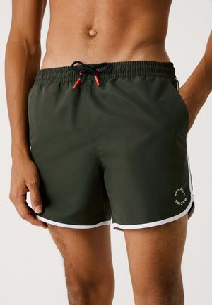 Shorts de bain pour hommes en tissu vert foncé, avec une taille élastique, un cordon noir avec des embouts rouges, et des accents en blanc. Logo présent.