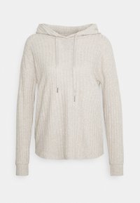 Sudadera de color beige claro hecha de tela acanalada. Presenta una capucha con cordón, mangas largas y un corte relajado.