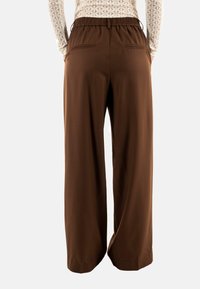 Bruine wijduitlopende broeken met een elastische tailleband, twee achterzakken, een gladde textuur en een vloeiende uitstraling. Geschikt voor casual draag.