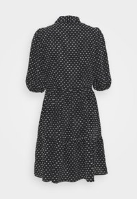 Robe courte noire avec petits motifs carrés blancs, manches ballon mi-longues, taille cintrée et jupe à volants, vue de dos.
