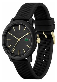 Montre-bracelet en caoutchouc noir avec un cadran texturé noir, des index heures dorés et des aiguilles dorées. Présente un logo accentué et un bracelet ajustable.