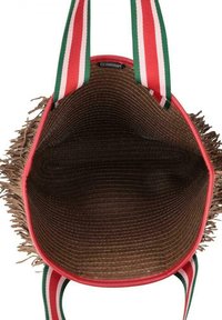 Rode tote bag met een rieten franjes, voorzien van groen en rode gestreepte hengsels. Het interieur heeft een gladde bruine voering met een gestructureerde stiksel.