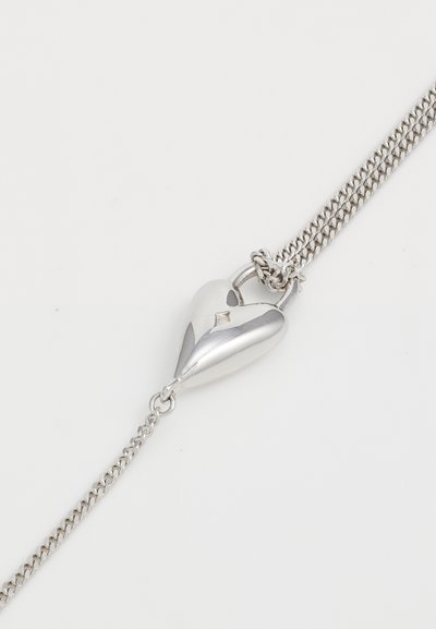 Lănțișor de argint gros, cu un pandantiv în formă de inimă, dotat cu un mic accent de diamant pe față, cu o textură netedă și lustruită.