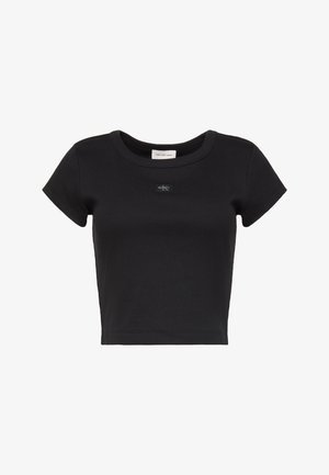 Must lühikeste varrukatega lühendatud soonikkoega T-särk ümmarguse kaelusega ja väike Calvin Kleini logo plaastriga, mis asub rinna keskel.