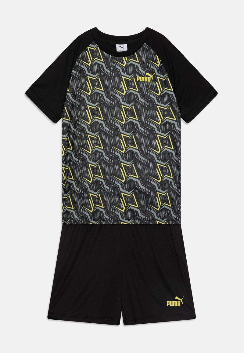 Conjunto atlético negro que incluye una camiseta de manga corta con un patrón geométrico dinámico en gris y amarillo, y pantalones cortos negros a juego.
