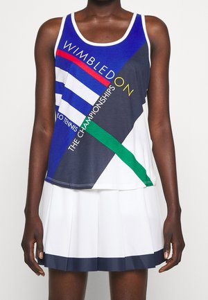 Bezrękawnik tenisowy z niebieskimi, białymi, czerwonymi, zielonymi i czarnymi ukośnymi paskami oraz napisem „Wimbledon The Championships”, zestawiony z białą plisowaną spódnicą.