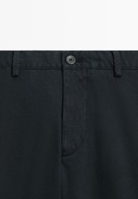 Black trousers with a smooth texture, featuring a button closure and belt loops, and a single pocket on the front.