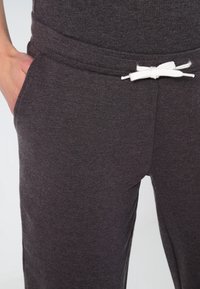 Grijze katoenen joggingsbroek met een elastische tailleband en een witte trekkoord. Voorzien van zijzakken en een zachte textuur.