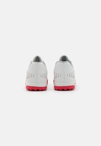 Gray athletic shoes with pink rubber soles and textured accents, featuring perforations on the sides for breathability and a sleek design.