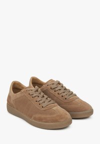 Brown suede sneakers with round toes, textured upper, flat laces, and rubber soles. Subtle stitching and side panel accents.