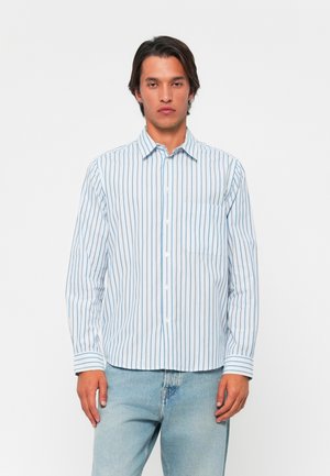 Long-sleeve button-up shirt in light blue with vertical white stripes, featuring a chest pocket and a classic collar. Soft fabric texture.