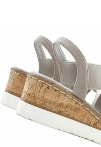 Gray suede sandals with two wide straps, a cork wedge heel, and a white rubber sole. Includes stitching detail along the cork edge.