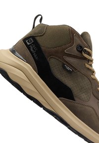 Bruine hoge wandelschoenen van een mix van suede en mesh materialen, met zwarte accenten, een getextureerde zool en een beige rubberen buitenzool.