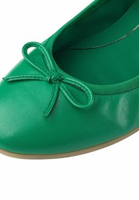 Ballerine in pelle verde con punta arrotondata, dotata di un piccolo fiocco decorativo. Texture liscia e suola in gomma flessibile.