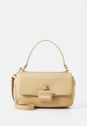 Beige faux leather handbag with a top handle, detachable shoulder strap, gold hardware, and a flap closure featuring a logo plaque.