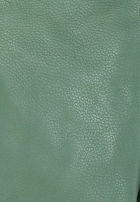 Groene, gestructureerde leren oppervlakken met een klein, korrelig patroon dat doet denken aan kiezelstenen en een lichte glans.