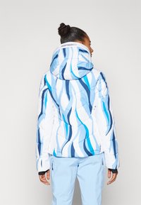 Gepolsterte Jacke mit einem blau-weißen Wellenmuster, ausgestattet mit Kapuze und gestepptem Textil. Der Stoff wirkt glatt und glänzend.