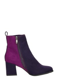 Bottines en suède avec un design en blocs de couleur violet et magenta, dotées d'une fermeture éclair sur le côté et d'un talon carré. Texture lisse et forme structurée.