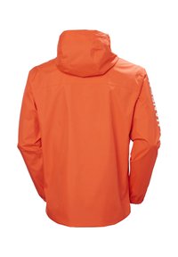 Oranje waterdichte jas met een capuchon, elastische manchetten en een wit logo op de mouw. Glad, duurzaam materiaal met een relaxte pasvorm.