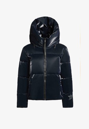 Veste matelassée bleu marine avec une finition brillante, grande capuche, fermeture éclair et sections matelassées bien visibles. Comprend un logo sur la manche.