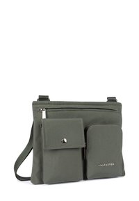 Borsa a tracolla in nylon verde con due tasche frontali, una delle quali con chiusura a scatto, tracolla regolabile e logo in evidenza sul davanti. Texture liscia e forma rettangolare.