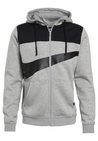 Šedá zipová mikina s černou kapucí a velkým černým logem Nike přes hrudník, s předními kapsami a stahovacími šňůrkami.