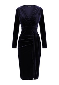 Velours jurk in diep marineblauw met lange mouwen, V-hals en gedrapeerde details rond de taille. Heeft een uitsnijding aan de voorkant voor een extra ontwerpelement.