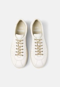 Sneaker bianche in pelle con profilo basso, dotate di lacci beige chiaro, dettagli testurizzati e punta liscia e arrotondata. Logo impresso all'interno.