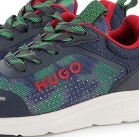 Baskets navy avec une tige en mesh vert et bleu, accents rouges et lacets gris. Logo "HUGO" notable en rouge sur le côté. Semelle texturée blanche.