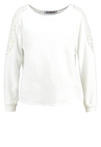 Top bianca a maniche lunghe con dettagli in pizzo su spalle e fianchi, scollo arrotondato, tessuto morbido e polsini a coste. Etichetta del marchio visibile all'interno.