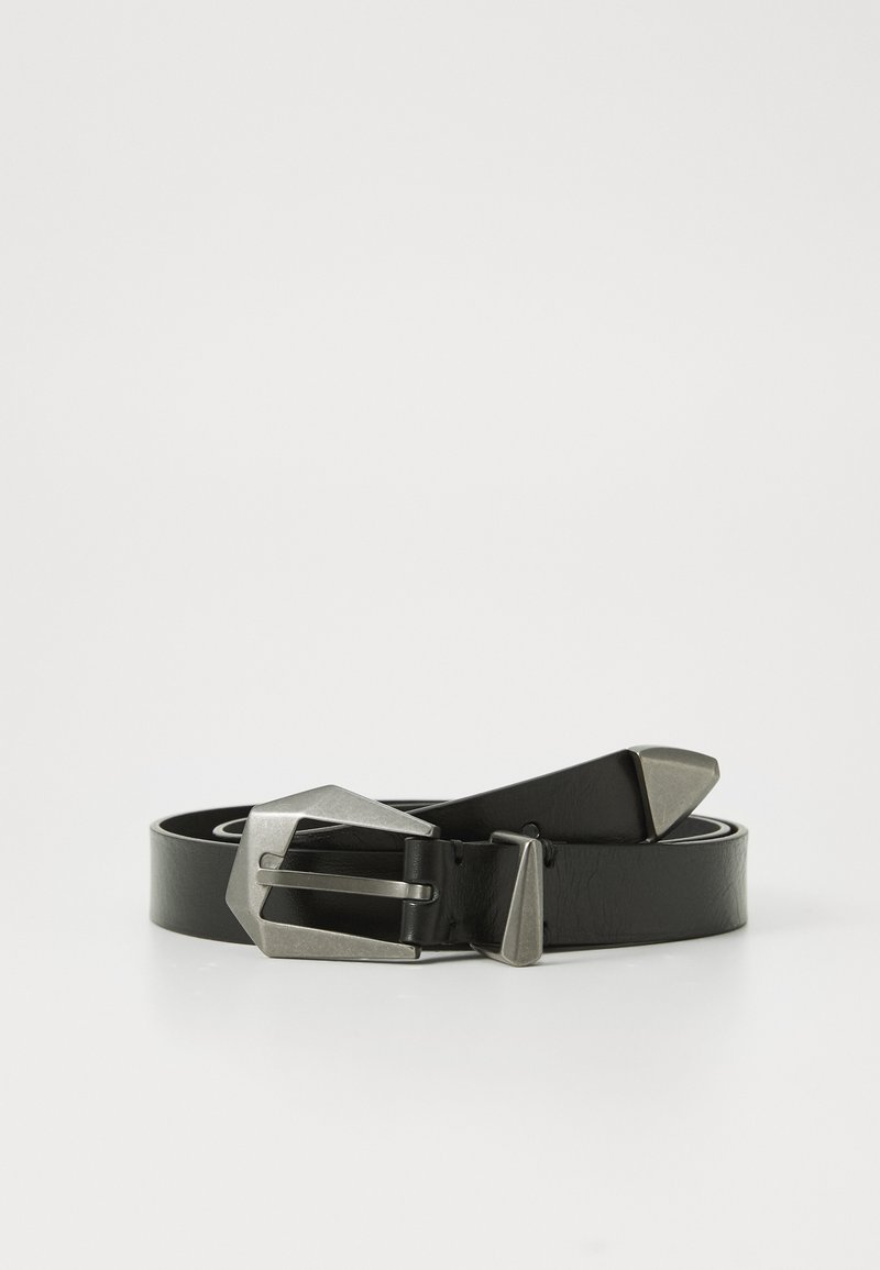 Ceinture en cuir noir enroulée avec une boucle en métal argenté, une boucle et un embout sur un fond blanc.