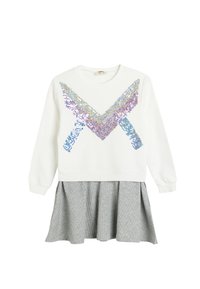 Hvid sweatshirts med et flerfarvet paliet-chevron design, tilsluttet en grå, plisseret nederdel med et struktureret mønster.