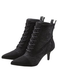 Botines negros hasta el tobillo con detalles de encaje, puntera afilada y un tacón bajo. Fabricados en ante y tela, cuentan con cordones decorativos y una lengüeta en la parte trasera.