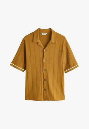 Horčicovo žlté krátke rukávy pletené tričko s vertikálnou rebrovanou textúrou, zapínaním na gombíky vpredu, otvoreným golierom a bielym pásikom na manžetách rukávov.