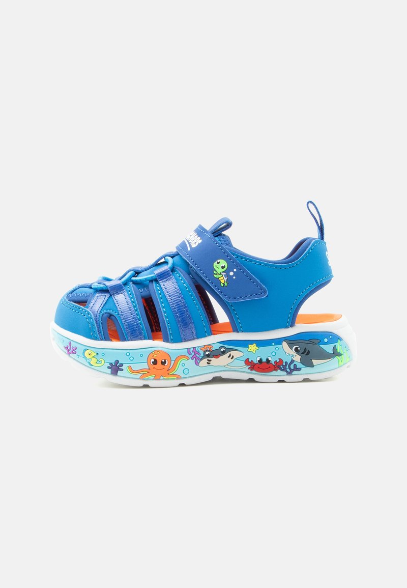 Sandale bleue pour enfants avec bouts fermés, bride ajustable et semelle décorée de créatures marines colorées en dessin animé.