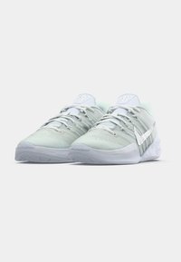 Light mint green athletic shoes with textured fabric, white laces, and a silver swoosh logo. Features a low profile and rubber sole.