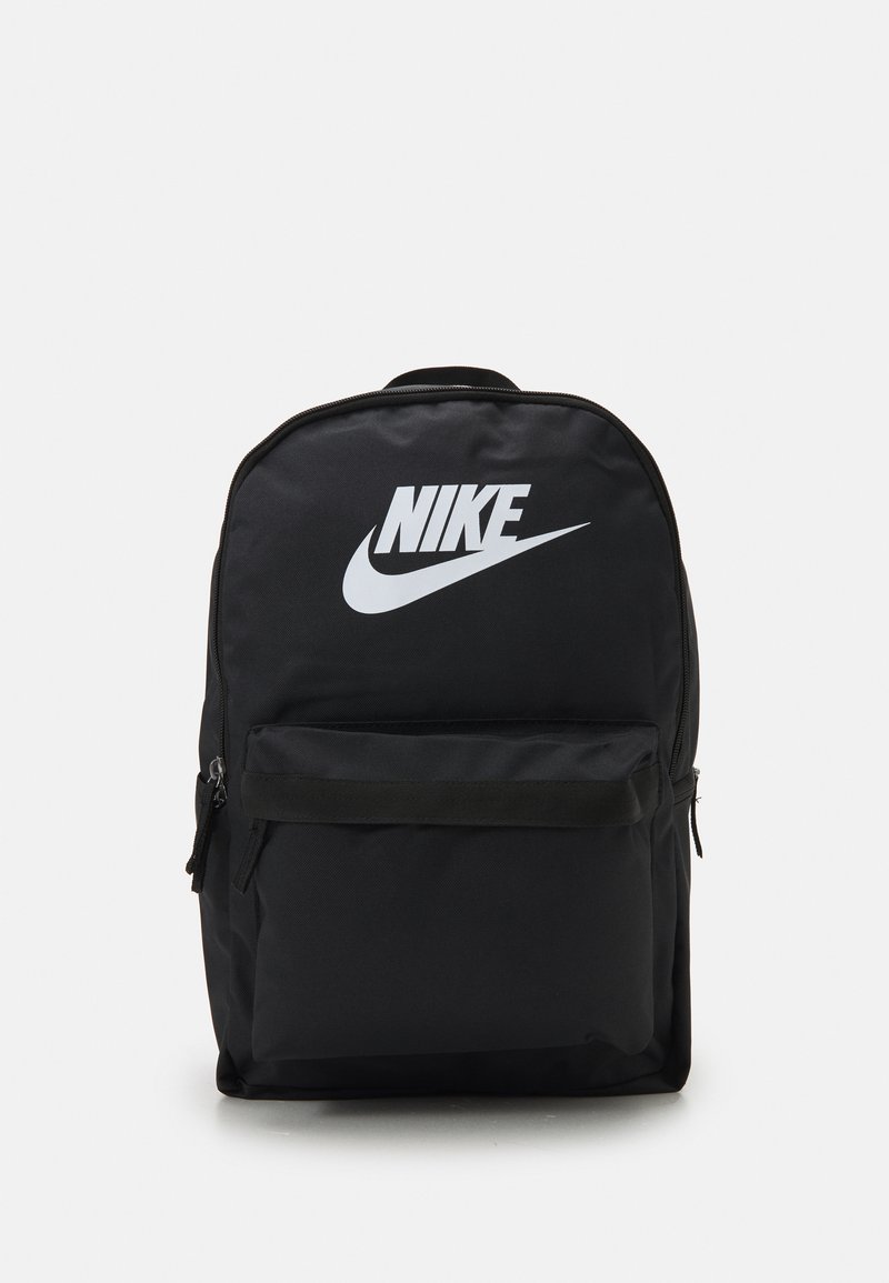 Svart Nike ryggsekk med stort hvitt logo, glidelås på frontlommen, rektangulær form og slitesterk tekstur.