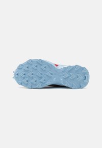 Blue rubber outsole of a shoe featuring prominent traction lugs, textured surface, and a red accent, designed for grip and stability.