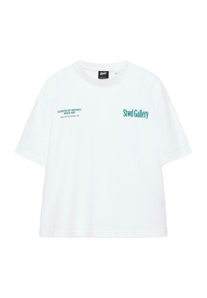 Biele tričko s krátkym rukávom s tyrkysovým nápisom "Stwd Gallery" na pravej strane hrudníka a "Curated by Instinct Since 1991" na ľavej strane hrudníka.